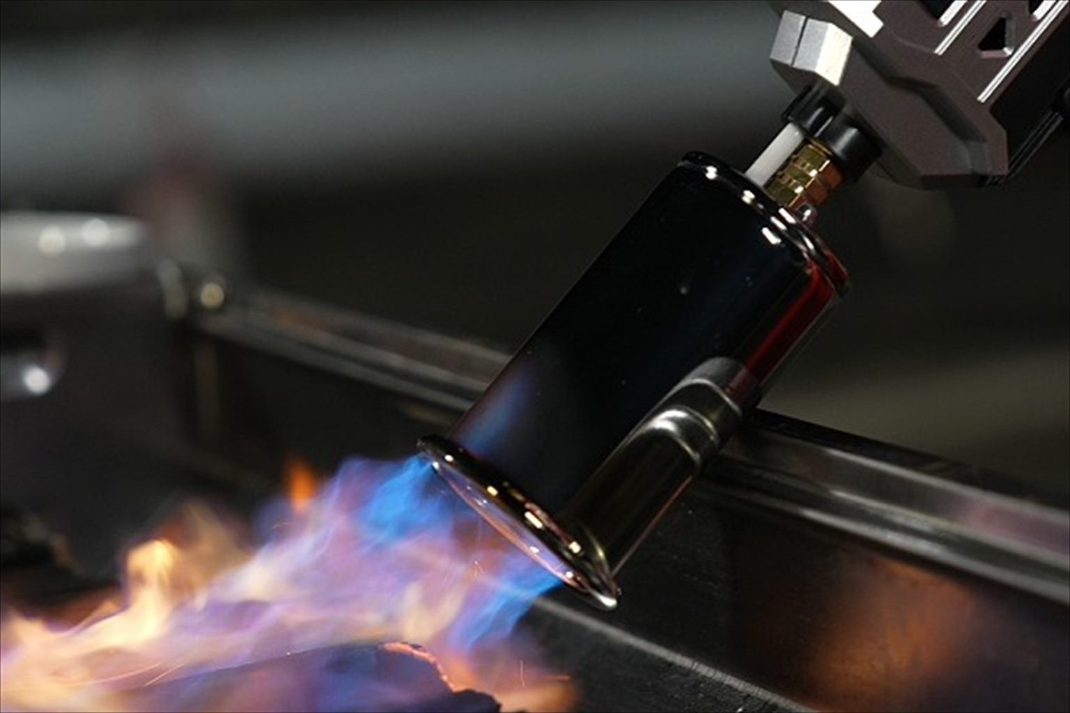 Real photo: lighting barbecue charcoal with a gas torch flame